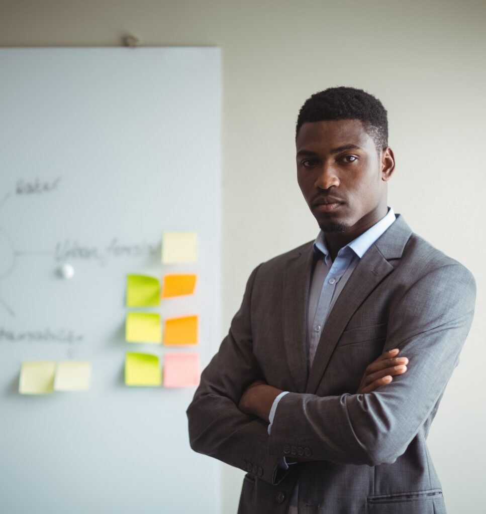 businessman standing with arms crossed in office businessman standing with arms crossed in office